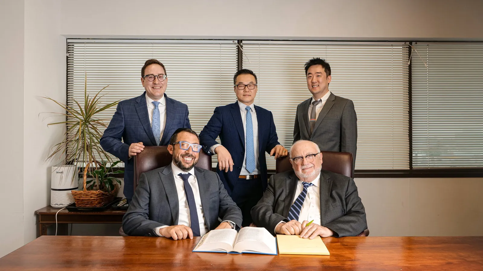 Vaturi & Cho LLP 변호사들이 회의 테이블에 함께 앉아 있는 사진