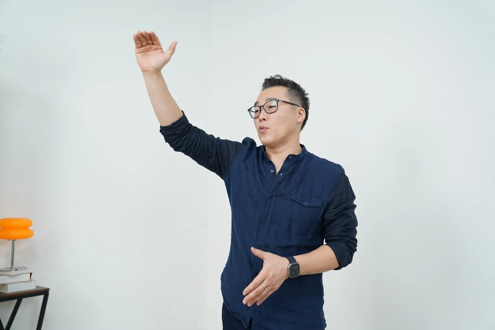 Jae Cho mid-sentence, one arm raised